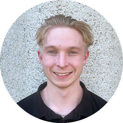 dylan-headshot A young man with short, blonde hair smiles in front of a textured, gray wall.